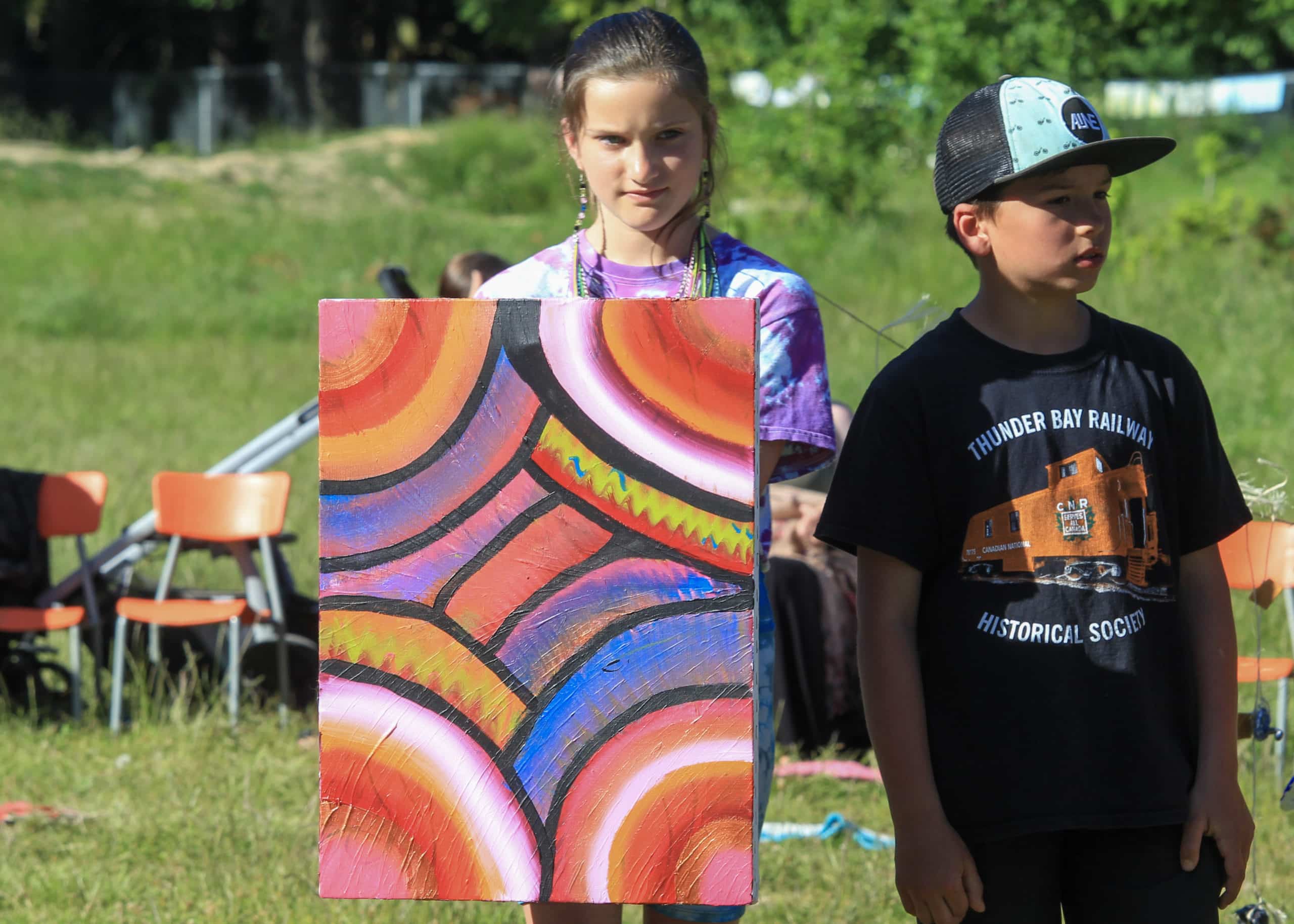 Vienna Wright presents her painting at the ceremony, with Simon Gleeson beside her. The painting has different coloured half-circles