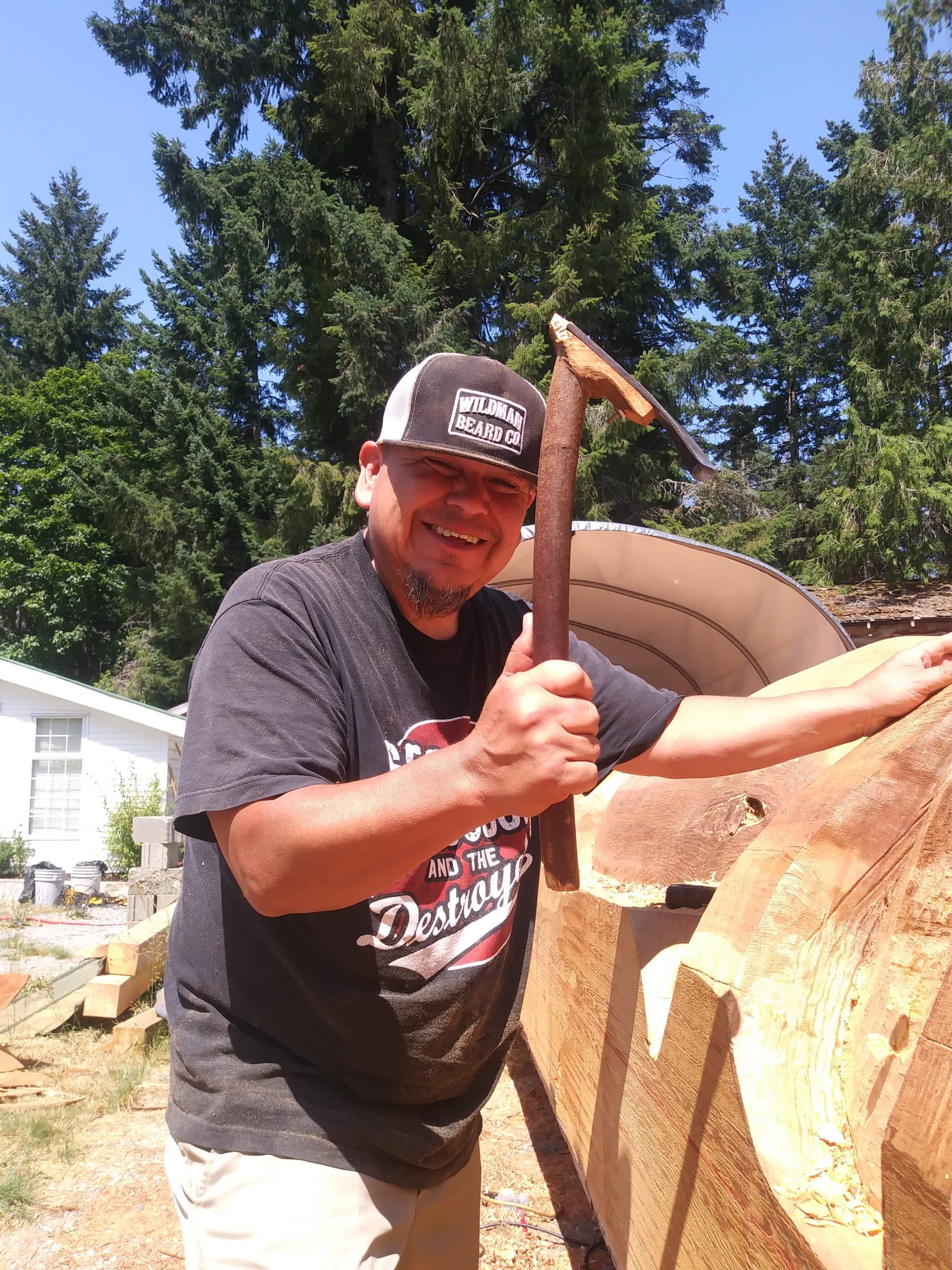 Carver Noel Brown tool in hand works on a welcoming pole to be featured at a Snuneymuxw village site.