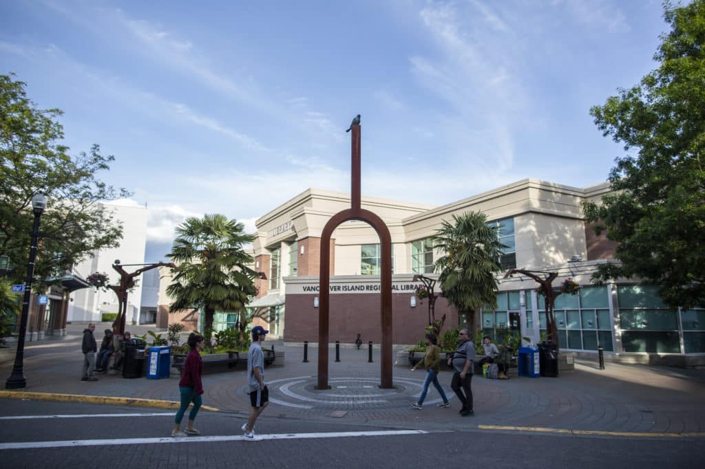 People walk through a public plaza outside the Vancouver Island Regional Library in downtown Nanaimo.