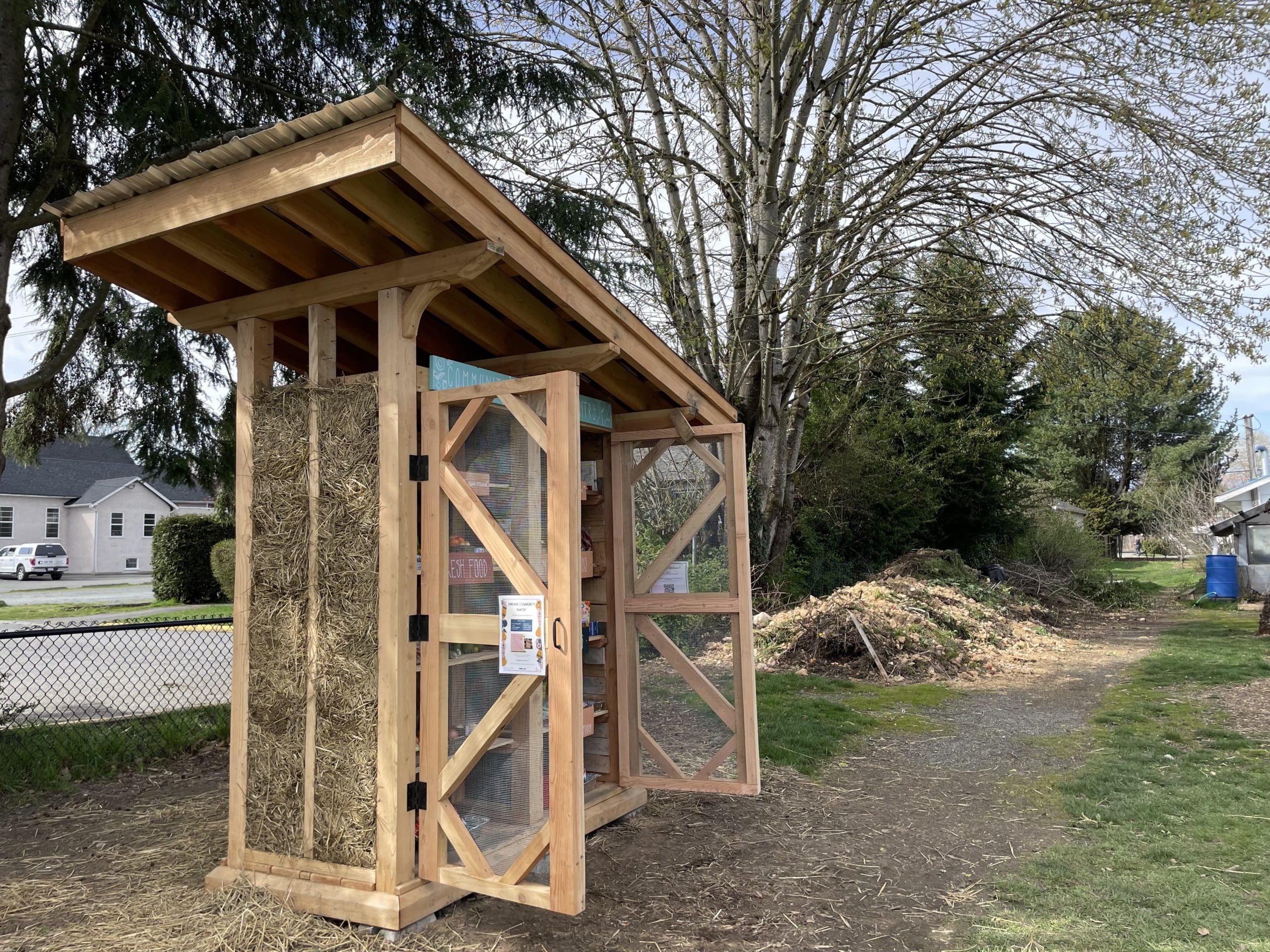 An image of the free food pantry and park in the background.