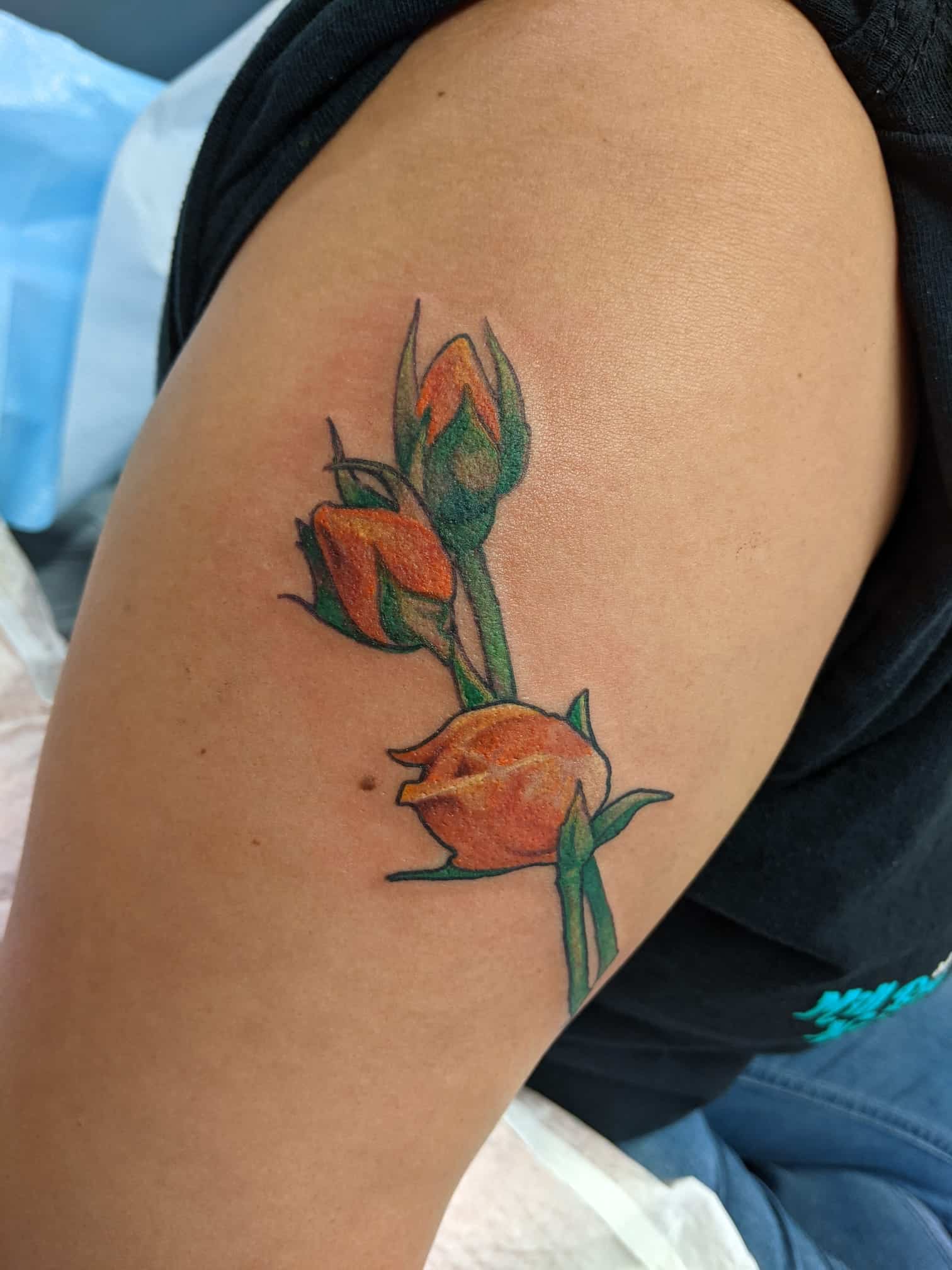 Hina Charania's tattoo of orange flower buds.Hina Charania’s tattoo of orange flower buds symbolizes the “buds who were not allowed to bloom” and honours the children who died at residential “schools.”