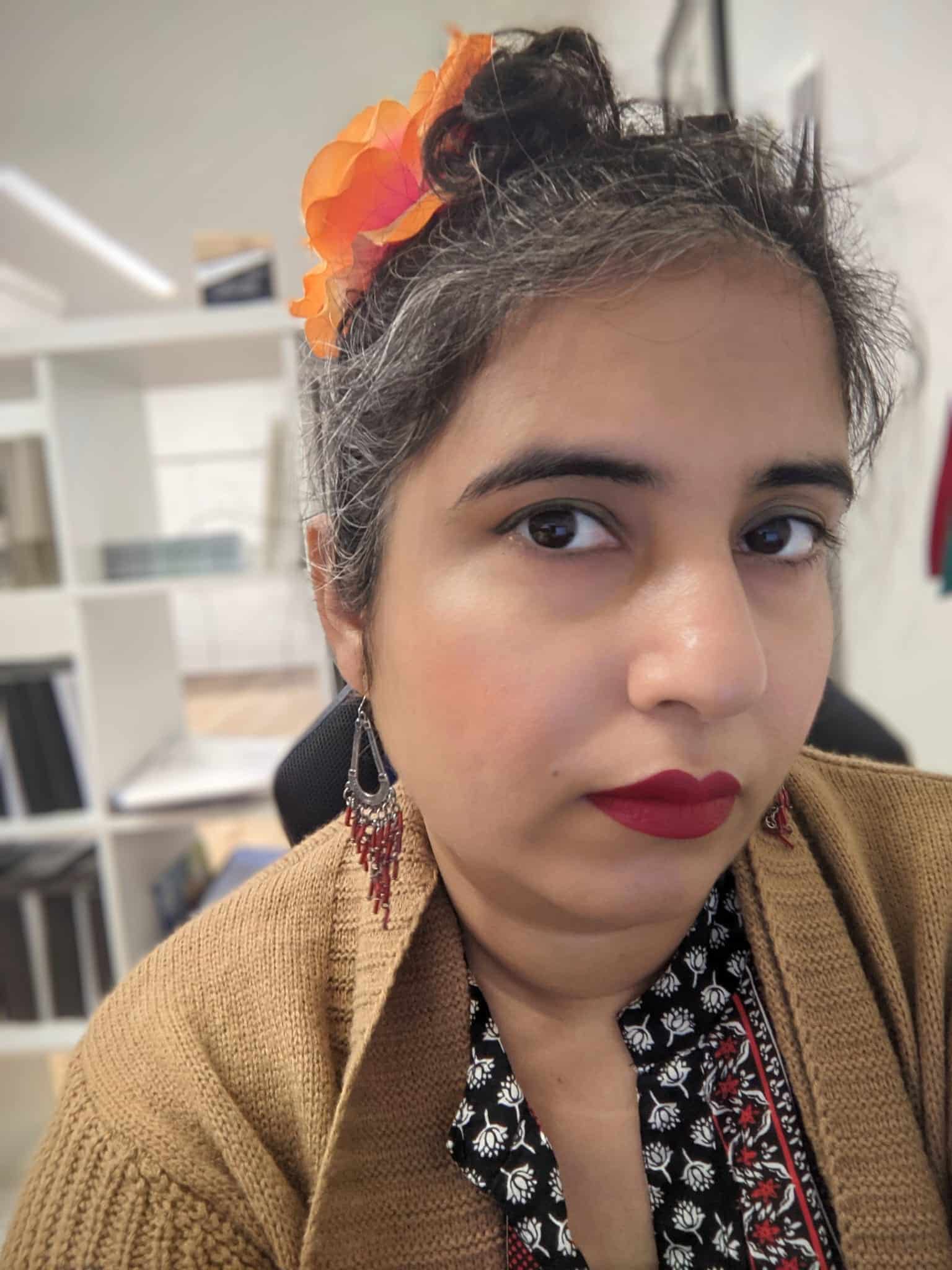 Hina Charania wears an orange flower in her hair.