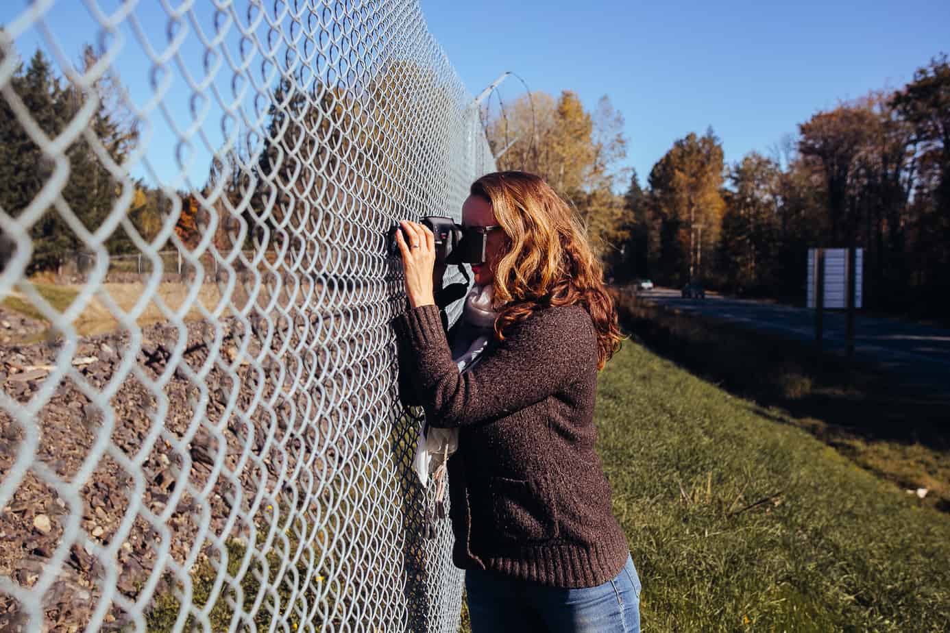 Jacqueline Ronson, reporter for The Discourse Cowichan, snaps a photo of the Vancouver Island Motorsport Circuit through the property's fence off Highway 18.