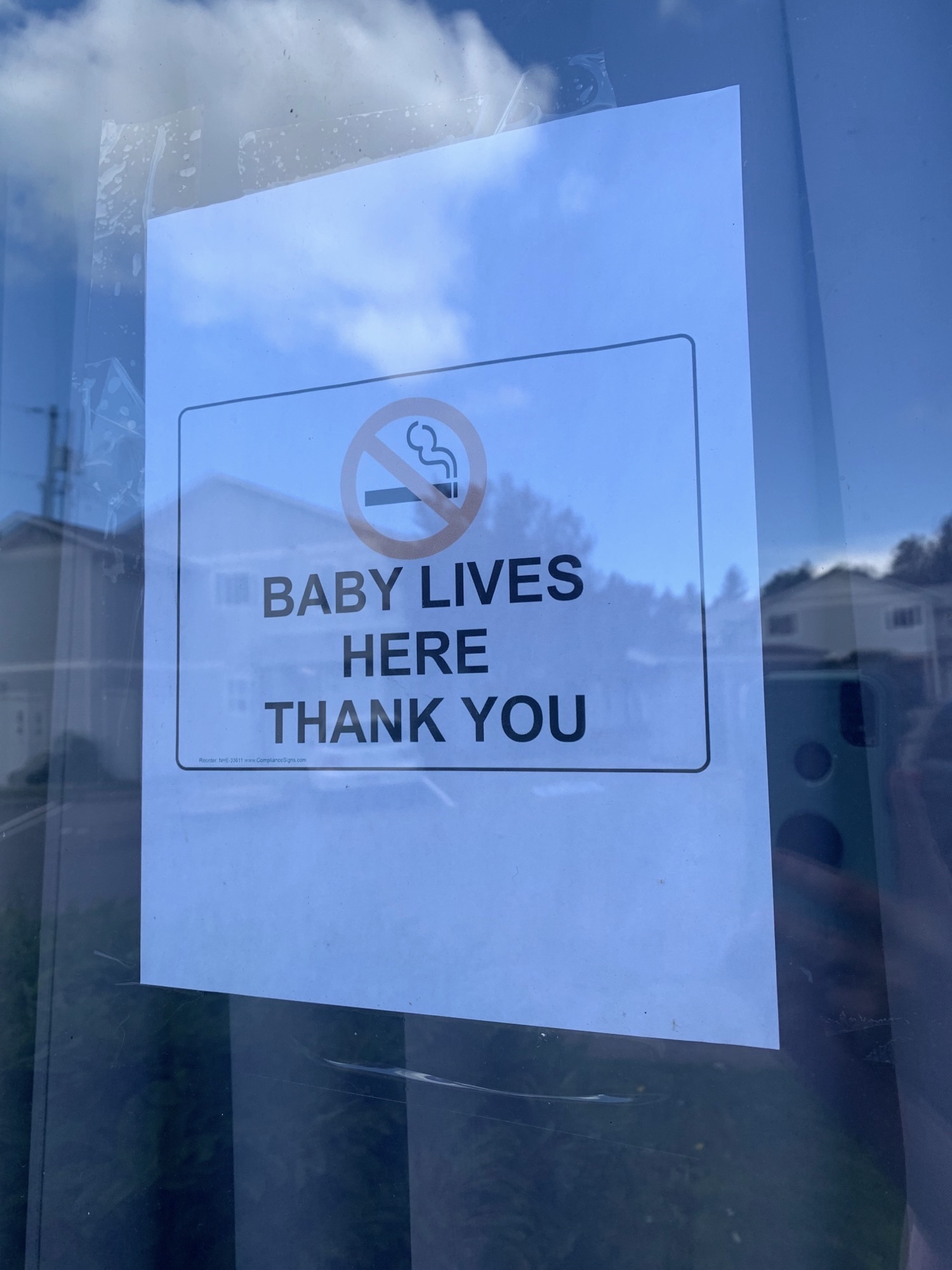 A sign displayed on Alexandria Hadlington's window reads "Baby lives here thank you" with a stop smoking symbol.