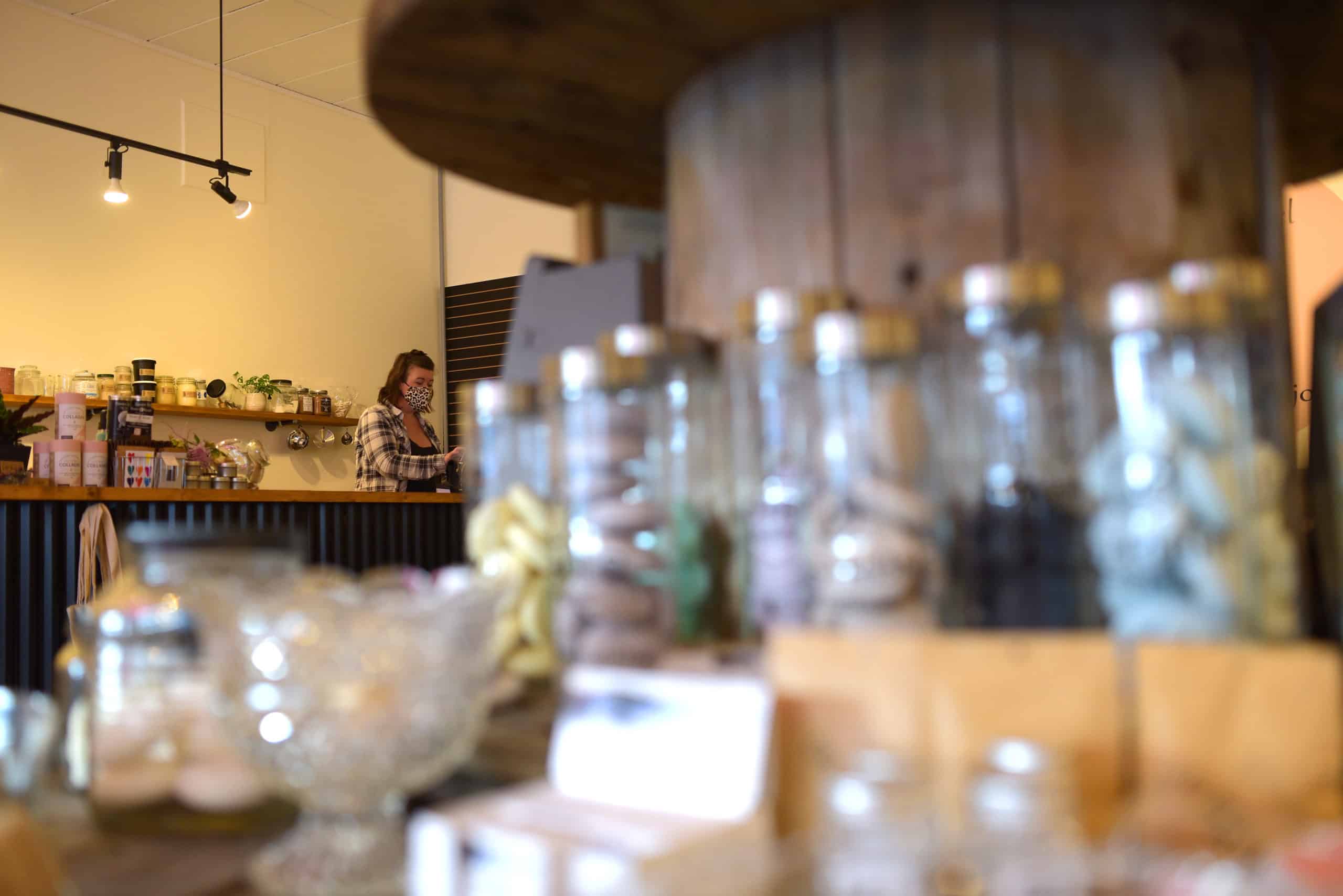 Stephanie Farrow is seen at the till helping a plentiFILL customer. In the foreground is store products.