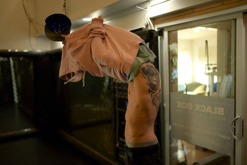 Shane Jung takes off his shirt to train at Black Box MMA, revealing a tattoo on his back. The lion represents himself, and cubs are being added for his children.