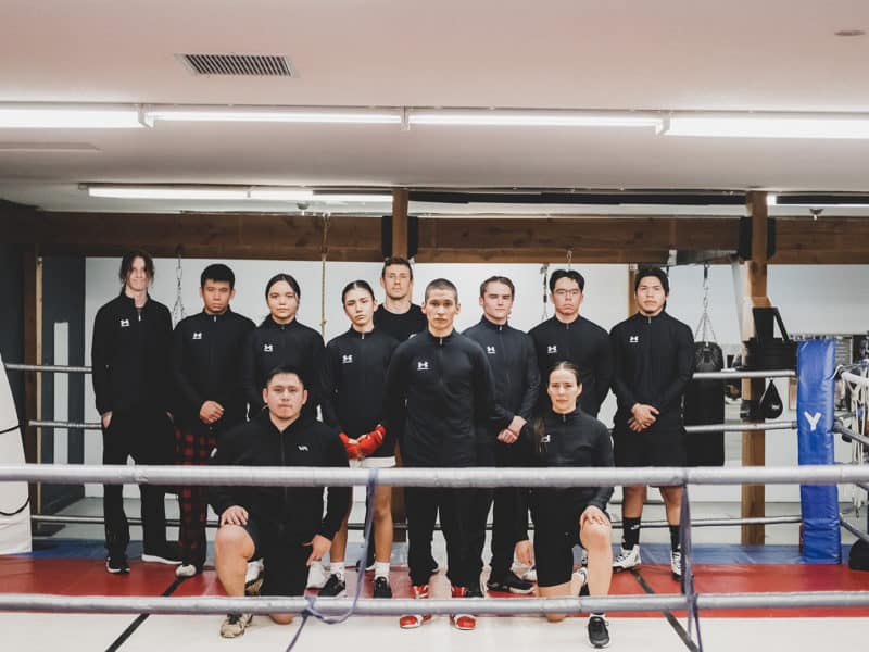 Members of Team 700 Indigenous youth boxing club stand for a group picture in the boxing ring.