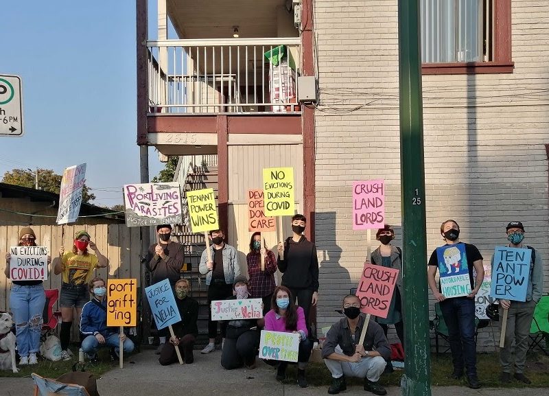 A dozen renters picket in front of a building in Vancouver holding signs in protest of an eviction.