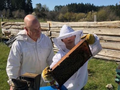 Ian Low and his son inspect a hive. Photo submitted by Ian Low