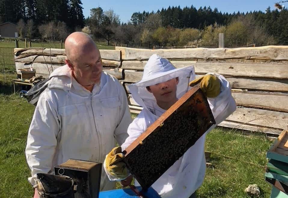 Ian Low and his son inspect a hive. Photo submitted by Ian Low