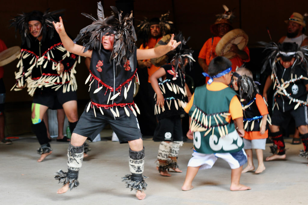 Young boys dance in regalia