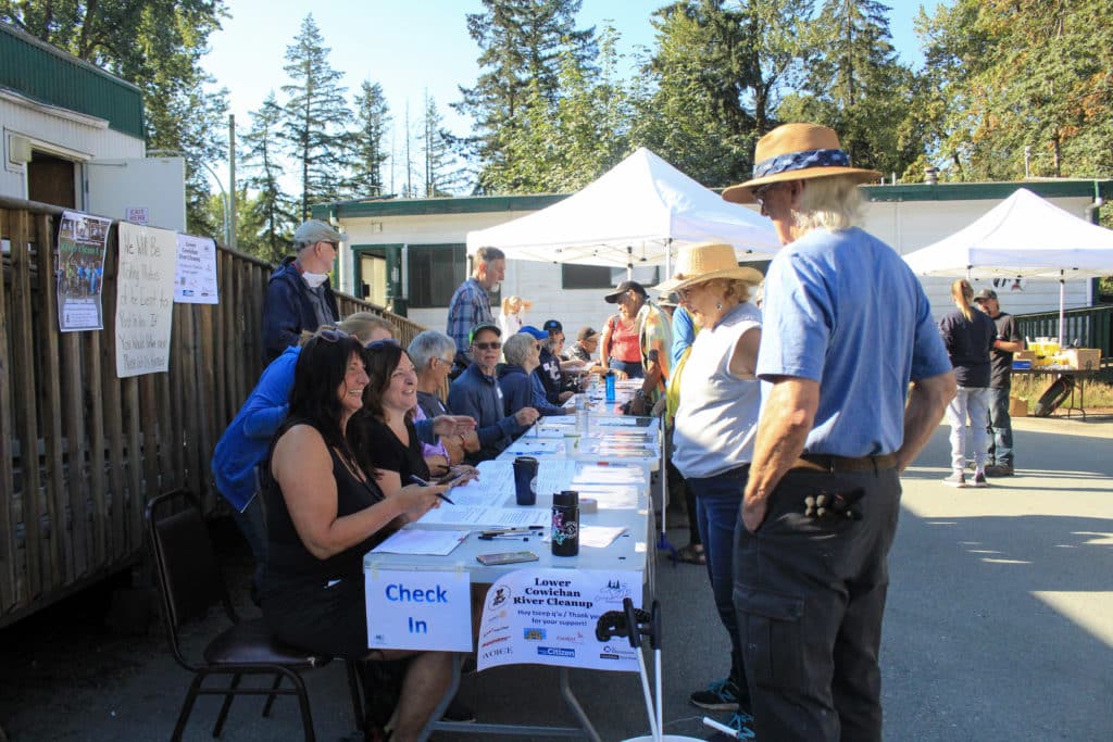 About a dozen people gather along a long outdoor table.