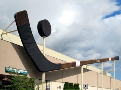 A giant hocker stick and puck sits over a large recreation facility building