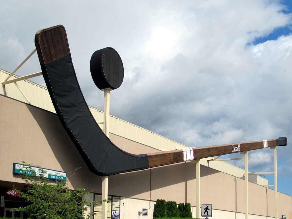 A giant hocker stick and puck sits over a large recreation facility building