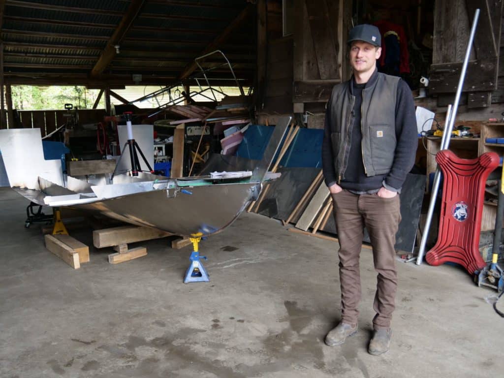 A person in a vest stands in a workshop wearing a vest.