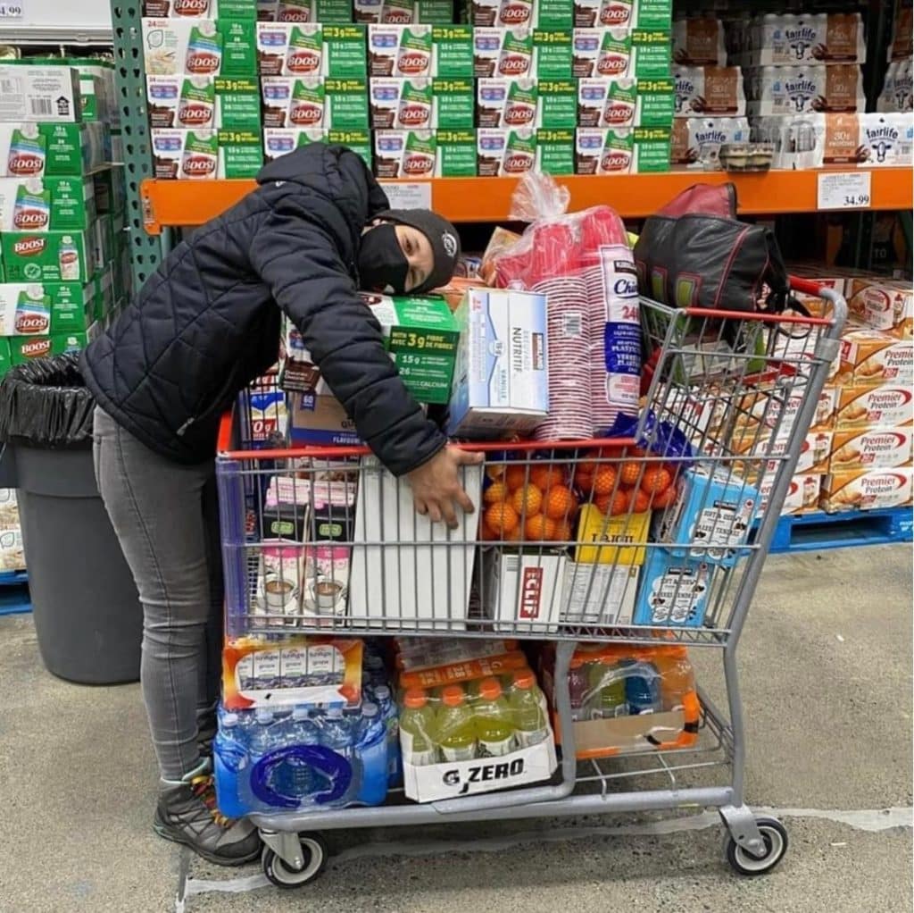 A person hugs a cart full of snack and supplies.