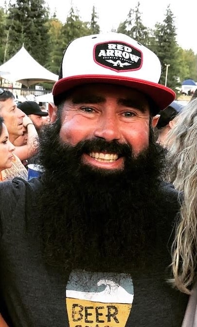 Bill Keserich Jr. smiling and wearing a Red Arrow Brewing ball cap.