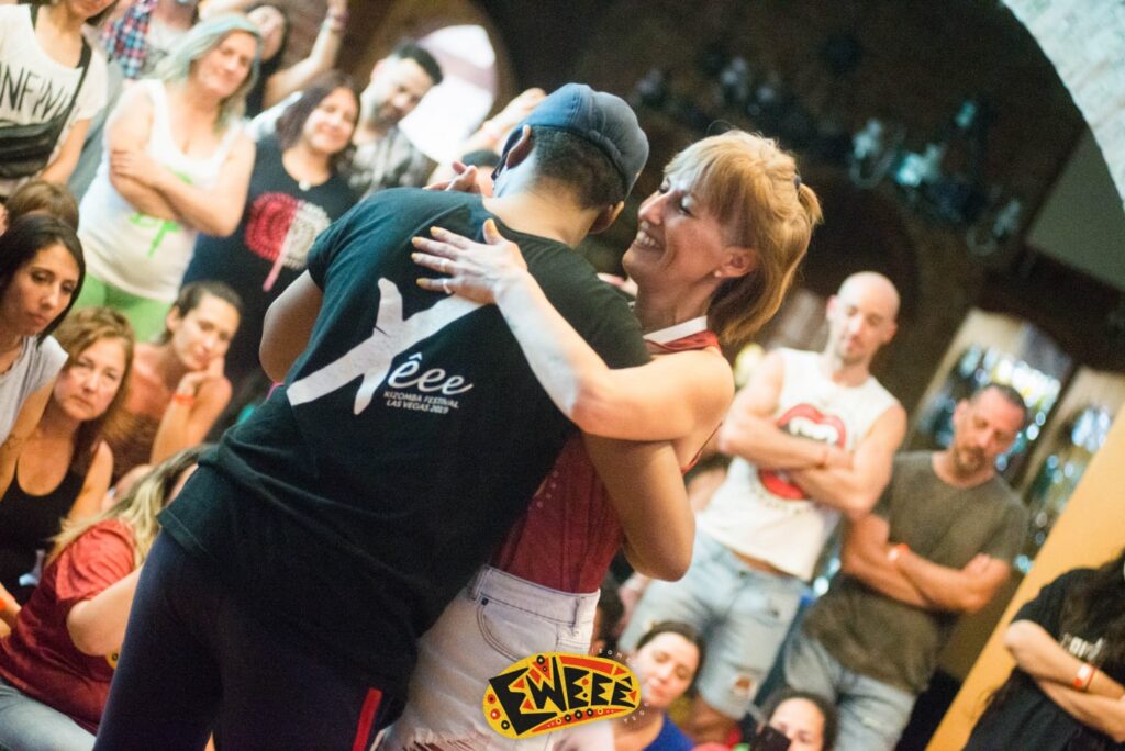 A couple embrace for a dance around smiling onlookers