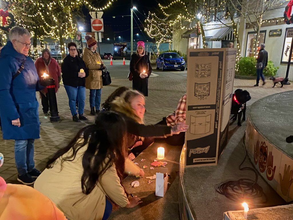 People kneel in front of a poster board