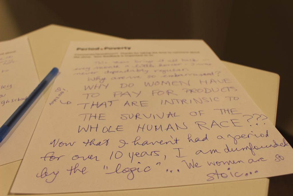 A comment page that says, in capitalized handwriting, "Why do women have to pay for products that are intrinsic to the survival of the whole human race???" In different writing, it says "Now that I haven't had a period for over 10 years, I am dumbfounded by the 'logic' ... We women are so stoic ..." and another note in different writing points to the first one and says "amazing!" with a heart drawn above it.