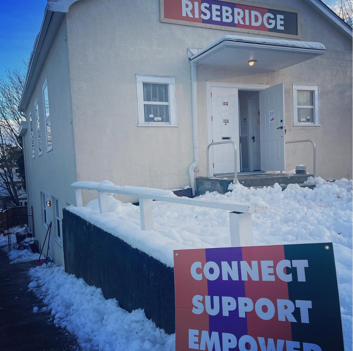 A white building that shows a colourful sign that reads Risebridge on the front