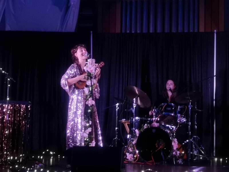 A woman on stage with a ukulele
