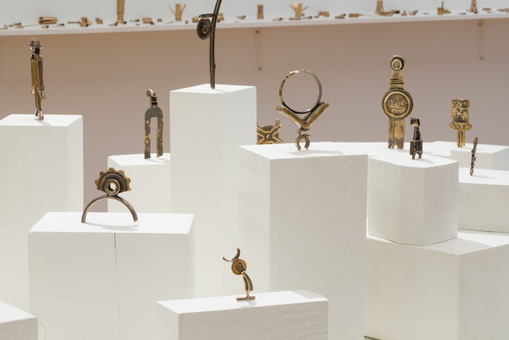 White plinths in a gallery show bronze sculptures made from beach plastic and wax that have been cast into bronze