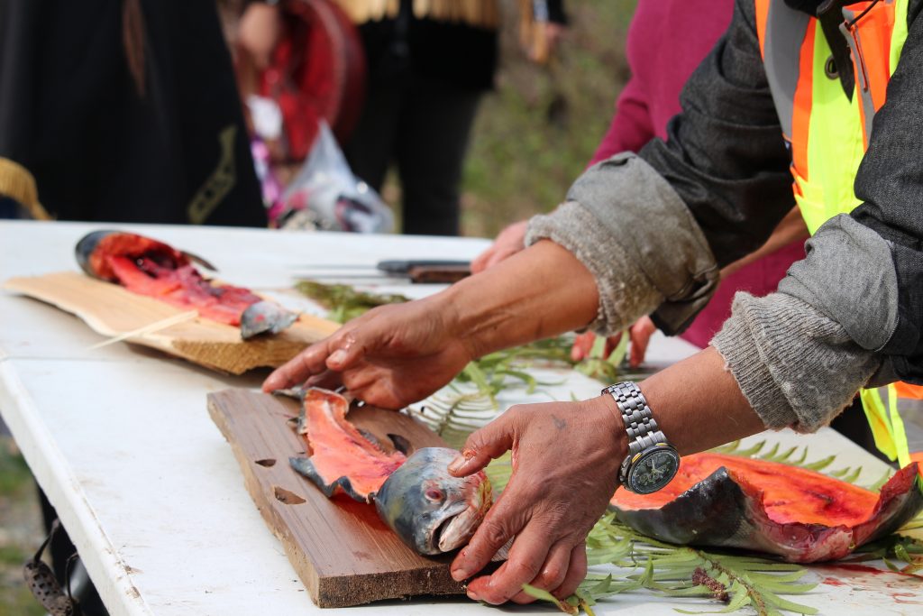 The spine and head of the salmon rest on cedar planks on the table.