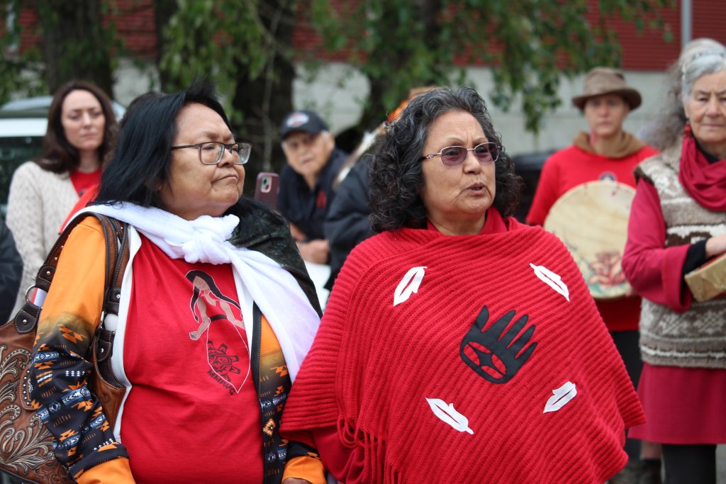 Monica Patsy Jones wears all red and addresses the crowd.