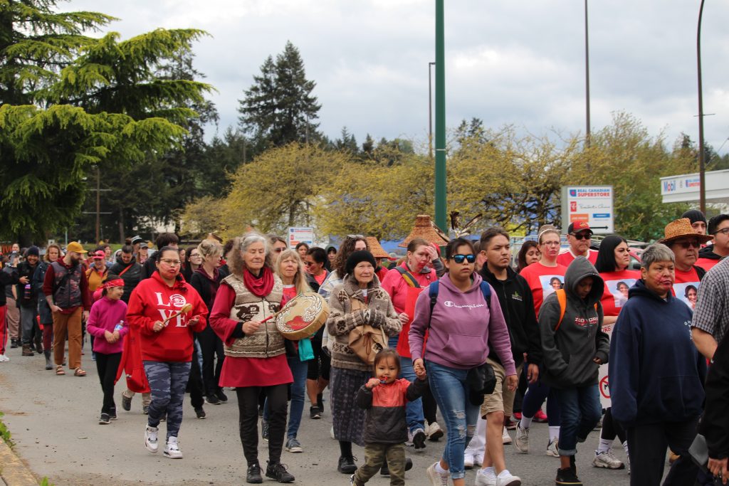 A large group of people wearing red march together.
