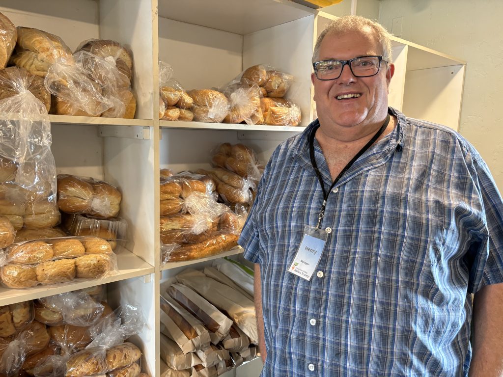 Cowichan Valley Basket Society manager, Henry Wikkerink stands in front of shelves of donated bread