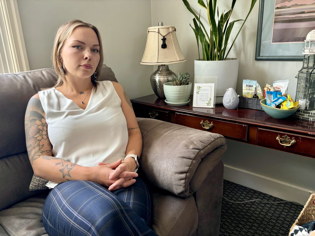 Zoe Lauckner, executive director of Cowichan Valley Youth Services, sits on an office couch, looking serious with hands clasped in her lap.