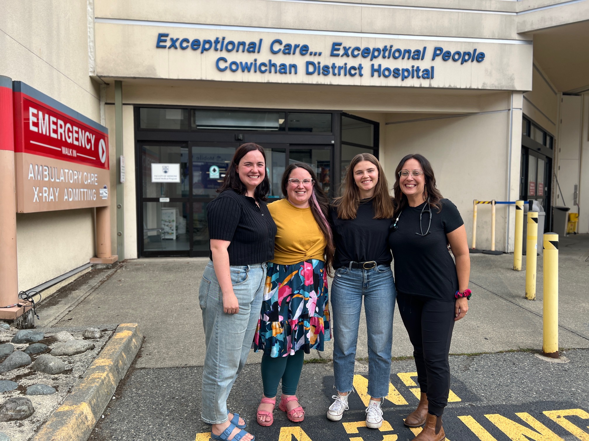 Four people stand in front of the emergency walk-in entrance at the Cowichan District Hospital.