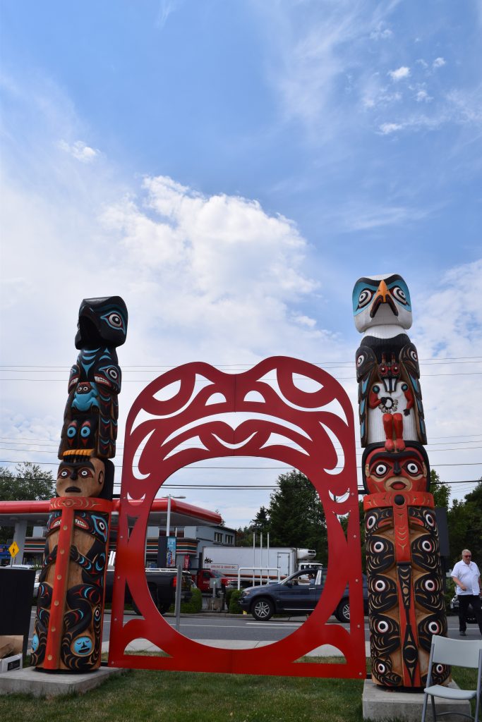 House posts designed by Joel Good seen standing in Stiil'nep (Departure Bay).