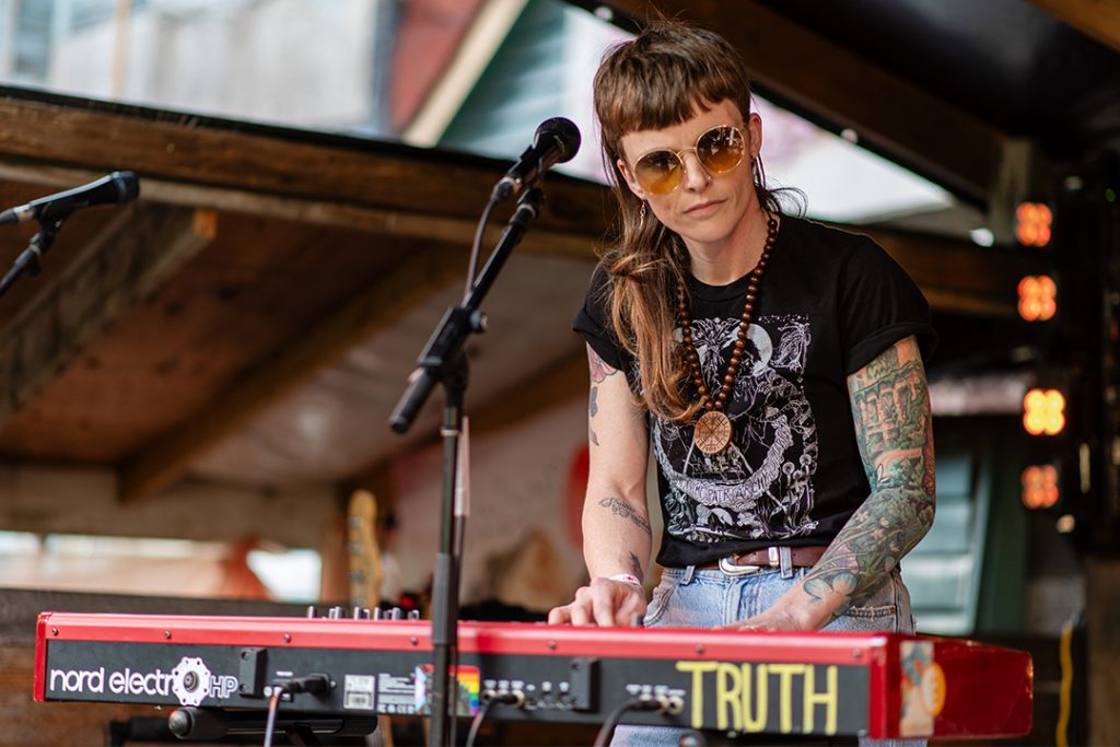 MJ McGregor plays a keyboard with the word TRUTH written on it at Backyard Fest 2024.