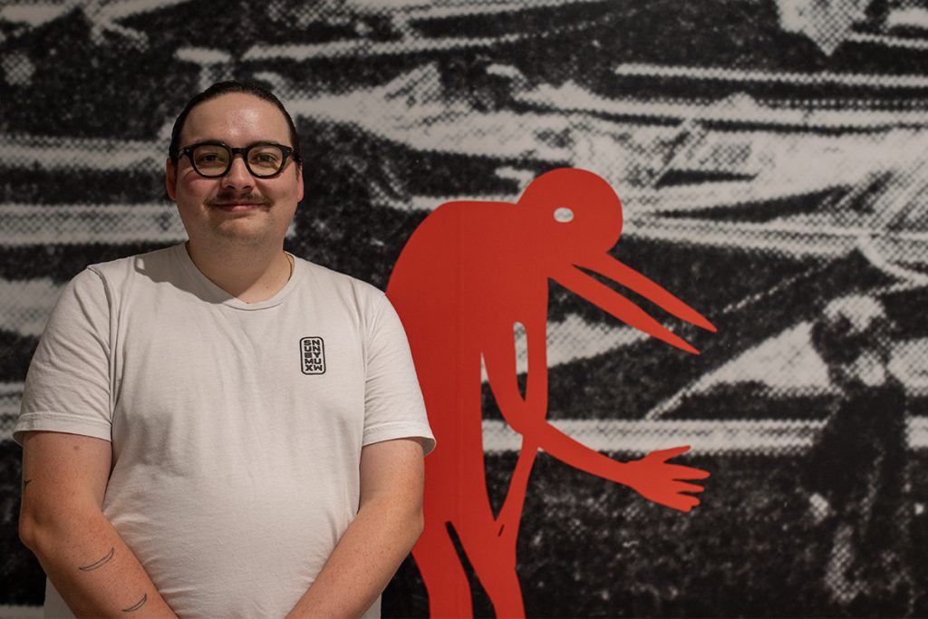 Eliot White-Hill, Kwulasultun stands in front of one of his pieces in the exhibit shnu’a’th, ᐊᑳᒥᕽ akâmihk, the other side, which will be on display at the Nanaimo Art Gallery until January 12, 2025. Photo by Mick Sweetman / The Discourse