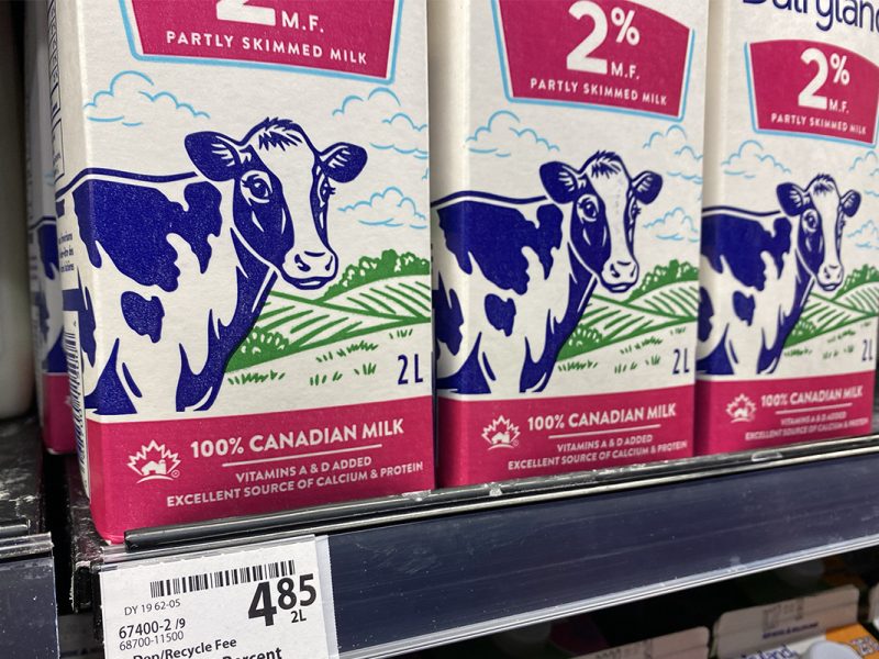 Photo of cartons of 2% Milk on a grocery shelf with the price of $4.85 for two litres.