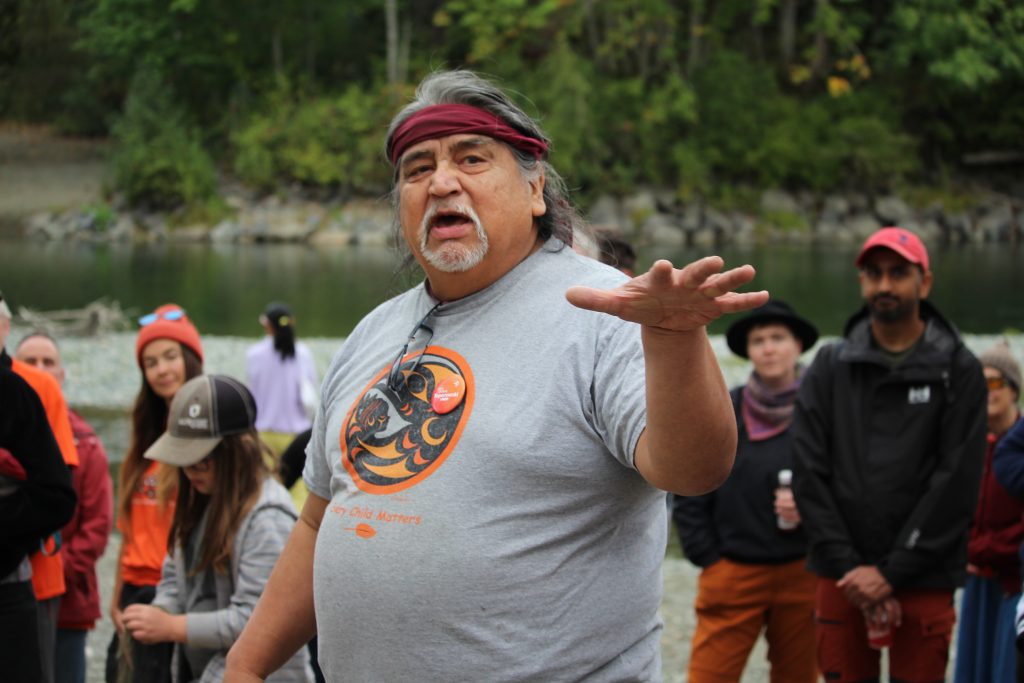 Herb Rice addresses a crowd gathered on the Cowichan River bank.